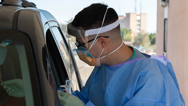 Air Force Staff Sgt. Bradley Gorman, a medical technician assigned to a military medical team deployed to Yuma, Arizona performs a nasal swab at the Yuma Regional Medical Center’s COVID testing drive-thru in Yuma, Jan. 17, 2022.
