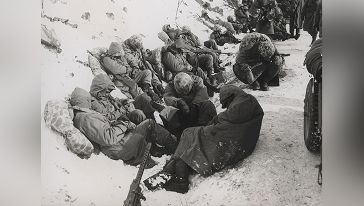 Exhausted and frostbitten U.S. Marines on the road South of Hagaru-ri, December 1950, waiting for a roadblock to be cleared during the Chosin Reservoir campaign November to December 1950. More than 8,000 men suffered frostbite in the subzero conditions, but new treatments and rapid transport to care saved many of their limbs from amputation. (From the Oliver P. Smith Collection, U.S. Marine Corps Archives and Special Collections)