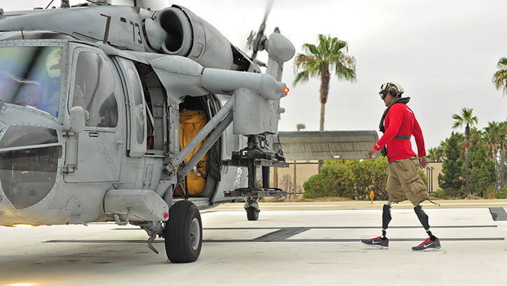 A man walks toward a helicopter.