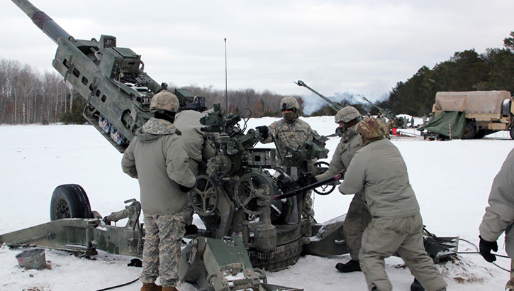 Image of Military personnel standing in the snow preparing to fire a missile .