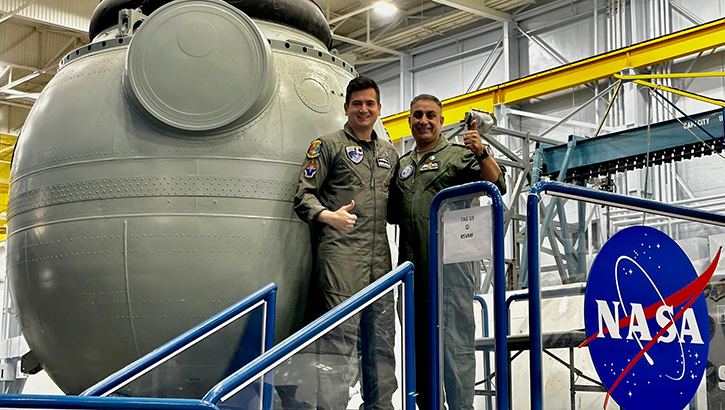 U.S. Air Force Lt. Vasileios Pastamentzas, Hellenic Air Force flight surgeon, and U.S. Air Force Lt. Col. Ra'fat Rahim Rahayfeh Habashneh, head of aerospace medicine for the Royal Medical Services in Jordan Armed Forces, stand in front of a Soyuz spacecraft at NASA. The two partners attended the Advanced Aerospace Medicine for International Medical Officers course. (Courtesy photo)