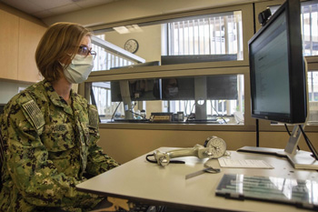 Military personnel looking at a computer screen