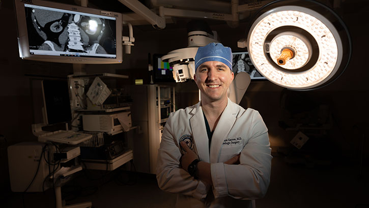 U.S. Navy Lt. Cmdr. (Dr.) Brandon R. Garren, the service chief of the Department of Urology at Walter Reed National Military Medical Center, poses for a photo in the operating room. The center recently implemented a single-port robotic surgical system. (Photo: Ricardo Reyes-Guevara, Department of Defense). 