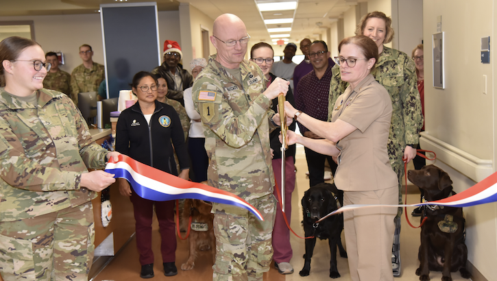 Nurses, physicians, and managers embraced one another during a ribbon-cutting ceremony and celebrated a new era in 4E's history. Amy O'Connor, a project manager under Walter Reed's Quality Directorate, even brought the base's service dogs to the ribbon cutting, celebrating today's festive 4E reopening. (Courtesy photo)