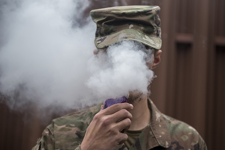 Image of A Team Offutt Airman vapes in an authorized smoking area during a break Nov. 7. As of Oct. 29, 2019, over 1,800 lung injury cases and 37 deaths have been reported to the Centers for Disease Control and Prevention and the only commonality among all cases is the patient’s use of e-cigarette or vaping products. Offutt Airmen looking for support quitting can schedule an appointment with a behavioral health consultant or primary care manager by calling 402-232-2273. To schedule a unit briefing on the dangers of vaping and options for quitting, call 402-294-5977. Outside assistance, including text-message support, is available by visiting www.smokefree.gov, www.thetruth.com or www.ycq2.org.  .
