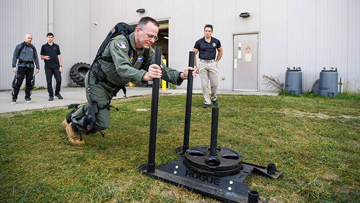 Military personnel pushes exoskeleton robotic fitness machine