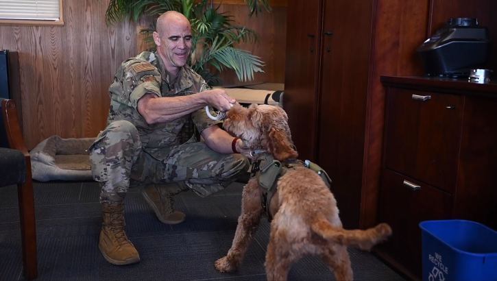 U.S. Air Force Col. Adam Roberts, the 555th Rapid Engineer Deployable Heavy Operational Repair Squadron Engineers (RED HORSE) commander, practices resiliency each day alongside his best friend and service dog, Porsche, a loveable labradoodle with golden brown fur resembling the look and feel of a stuffed animal.
